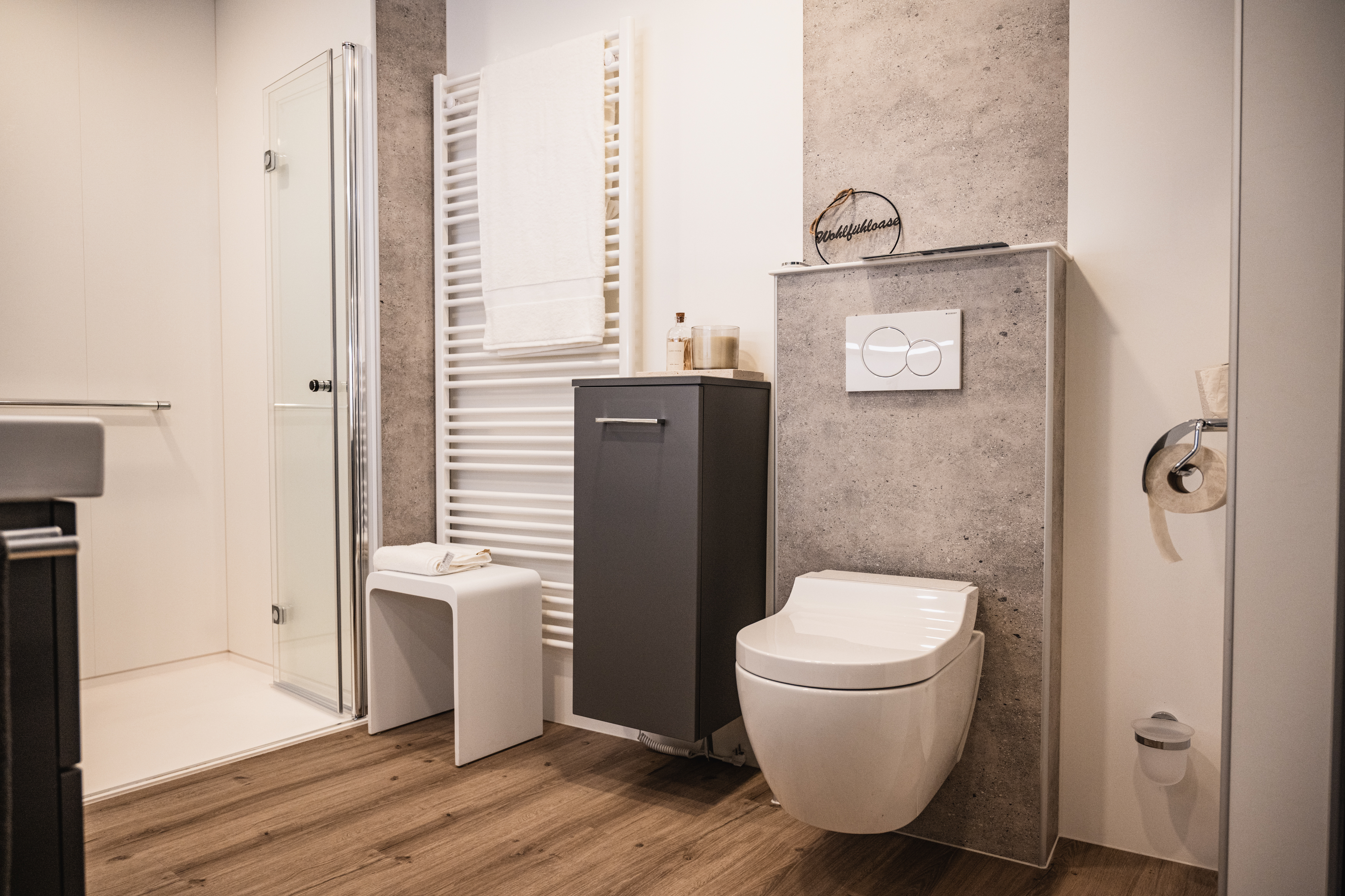 Modernes Bad mit Dusch-WC, Handtuchheizkörper und bodengleicher Dusche